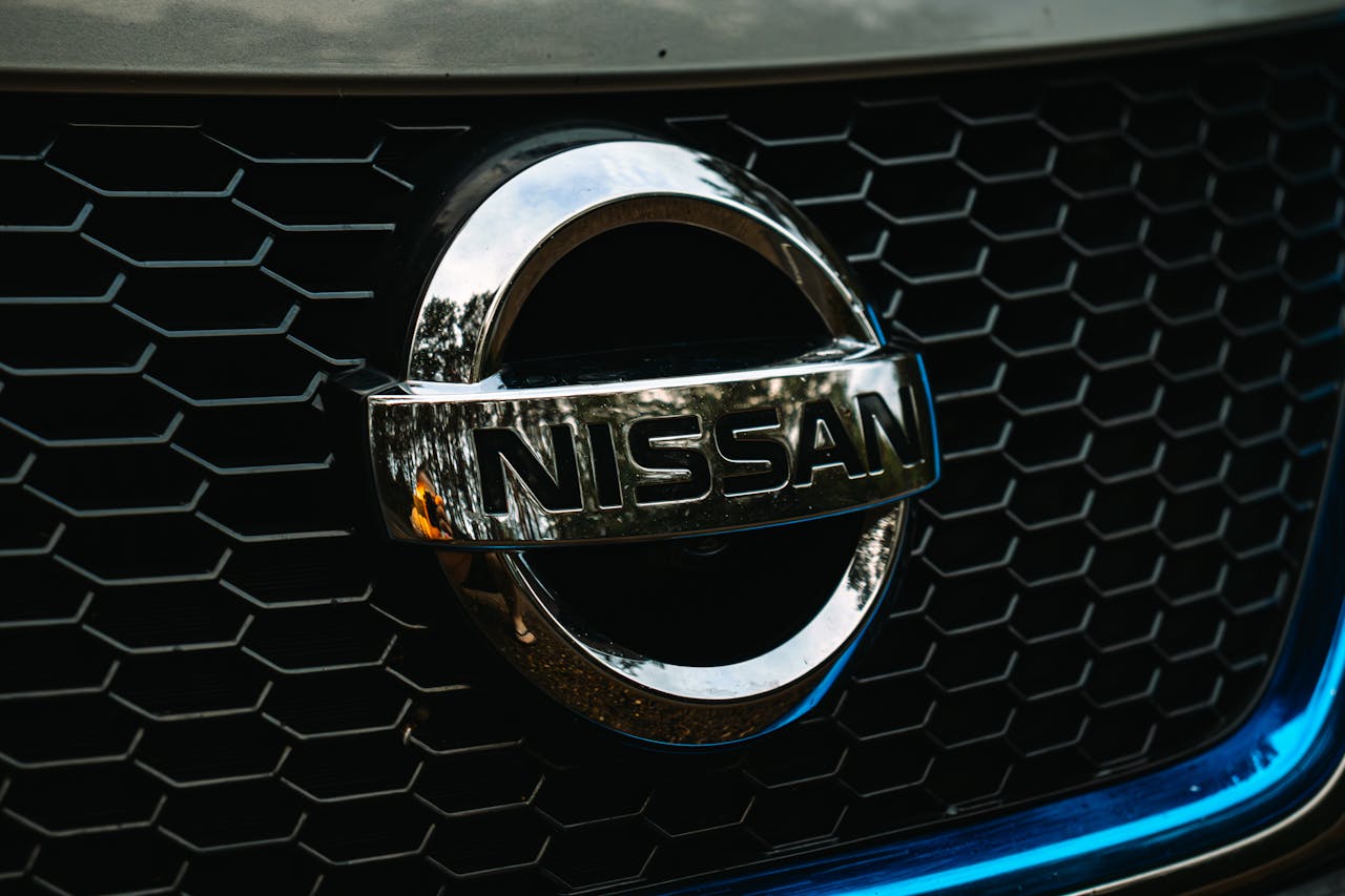 Crafting Captivating Headlines: Your awesome post title goes here Detailed shot of the Nissan logo on a car grille grid, emphasizing automotive branding.